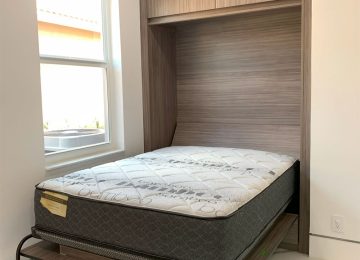Murphy bed open in small space condo bedroom with mattress